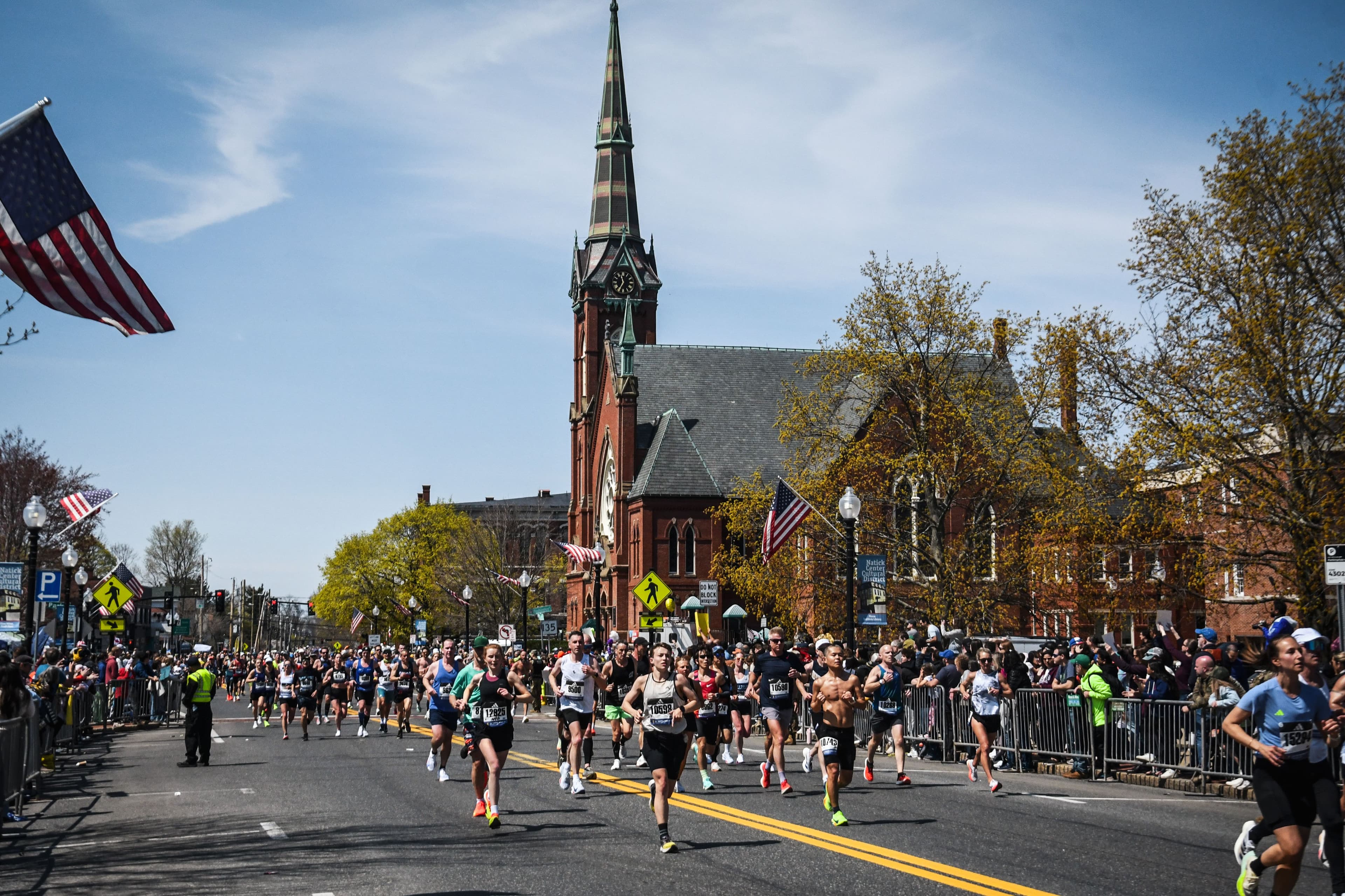 The Boston Marathon field running through Natick, ten miles in, crowds along both sides of the road